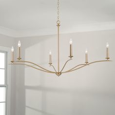 a chandelier hanging from the ceiling in a room with white walls and windows