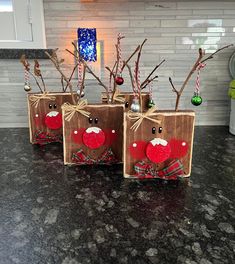 three small boxes decorated with christmas decorations on a kitchen counter top, one is red and the other is brown