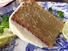 a piece of cake sitting on top of a blue and white plate next to a lemon wedge