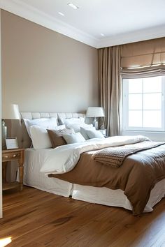 a large bed sitting in the middle of a bedroom next to a window with curtains