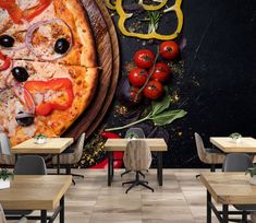 a pizza with tomatoes, onions and olives on the table in a restaurant wall mural