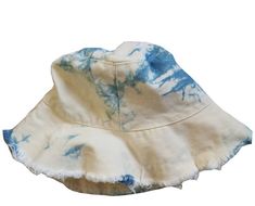 a white and blue tie dye bucket hat with frayed edges on the brim