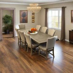 a dining room table with chairs and a bowl of fruit on it