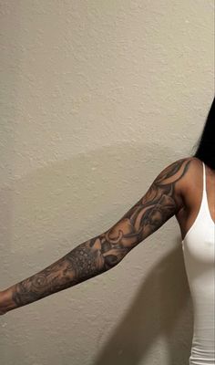 a woman with long black hair and tattoos on her arm is posing for the camera