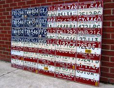 several license plates are stacked up against a brick wall