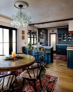 a dining room table with chairs and a chandelier hanging from it's ceiling