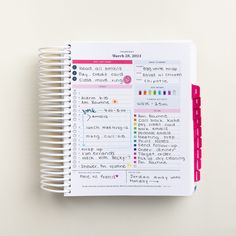 a spiral notebook with some writing on the page and colored markers attached to it