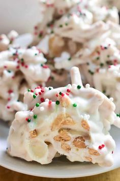 a white plate topped with cookies covered in frosting and sprinkles on top of a table