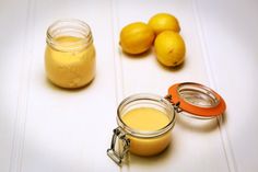 two jars filled with liquid next to lemons