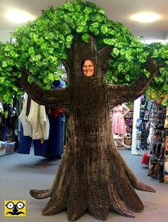 a man is standing in front of a fake tree