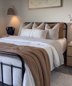 a bed with white sheets and pillows in a bedroom