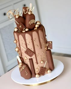 a three tiered chocolate cake with gold decorations