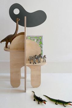 an elephant, zebra and crocodile toy stand next to each other in front of a white wall