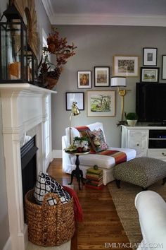 a living room filled with lots of furniture and pictures on the wall above it's fireplace