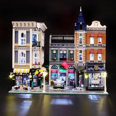 there is a lego town with many buildings on the front and back sides, all lit up at night