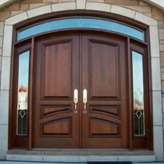 two wooden doors are shown in front of a brick building