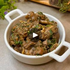 a white bowl filled with meat and vegetables