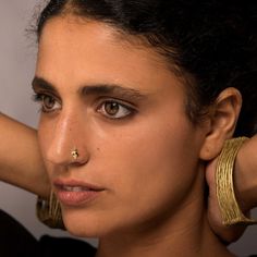 a close up of a person wearing gold jewelry