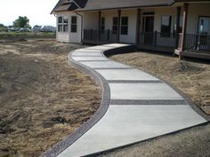 a concrete walkway in front of a house