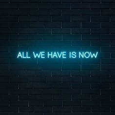 all we have is now neon sign on brick wall