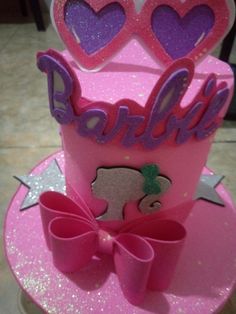 a pink birthday cake with hearts on top