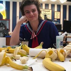 a person sitting at a table with bananas