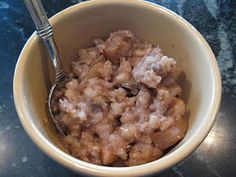 a bowl filled with oatmeal sitting on top of a table next to a fork