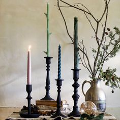 a table topped with candles next to a vase filled with flowers