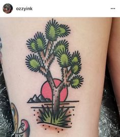 a small tree tattoo on the side of a woman's thigh