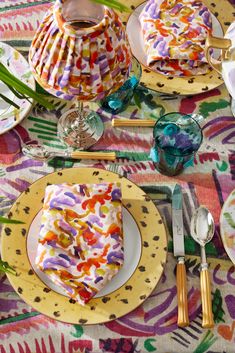 a table topped with plates covered in cake next to utensils and vases