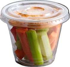 a plastic container filled with assorted veggies on top of a white surface