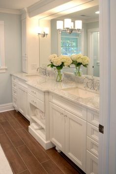 a large bathroom with two sinks and mirrors