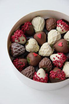 a white bowl filled with lots of different types of chocolates