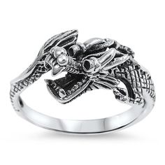 a silver ring with an image of a dragon on it's face and two skulls in the middle