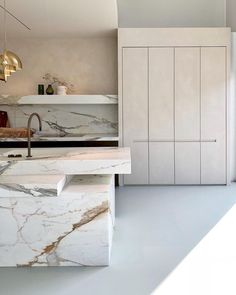 a kitchen with marble counter tops and white cabinets