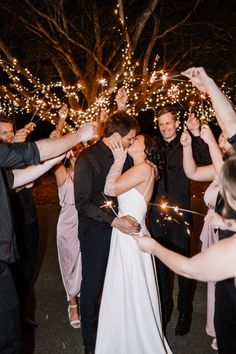 a bride and groom are surrounded by sparklers at their wedding reception in the evening