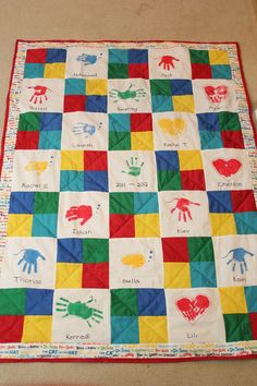 a colorful quilt with handprints on it in the shape of hearts and hands