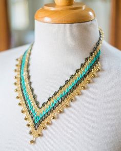 Necklace: Turquoise, Bronze and Gold Beads, Handmade with Czech Glass BeadsUnusual and elegant hand beaded necklace. The colors are wonderful and glisten.The T- closer is adjustable. There are gold colored crystal highlights at the point of each edge.Adds a sparkle. The necklace fits comfortably with a toggle closure. Easy to wear. Light weigt and elegant.This piece has been fabricated in Guatemala by indigenous Mayan bead artisans. Their work supports their families and communities. Each piece Beach Jewelry With Gold And Black Beads, Gold Jewelry With Black Beads For The Beach, Hand Beaded Necklace, Necklace Turquoise, Beads Handmade, Jewel Tones, Color Crystal, Czech Glass Beads, Hand Beading