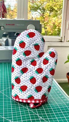 a oven mitt sitting on top of a cutting board