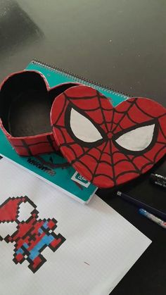 a box with a spiderman face on it next to some crayon markers