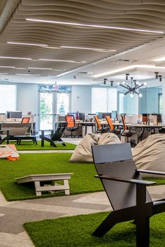 an office filled with lots of furniture and green carpeted flooring on the ground