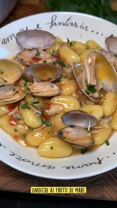 a white plate topped with pasta and clams