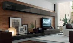 a living room filled with furniture and a flat screen tv on top of a wooden wall