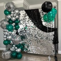 balloons and streamers in front of a mirror backdrop