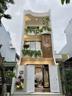 an apartment building with plants growing on it's sides and doors open to let in light