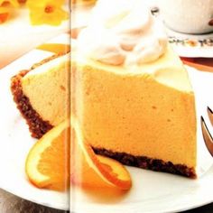 a slice of cheesecake with whipped cream and orange slices on a plate next to a fork