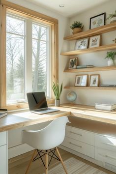 a laptop computer sitting on top of a wooden desk in front of a large window