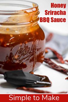 honey sriraca bbq sauce in a glass jar with a spoon next to it