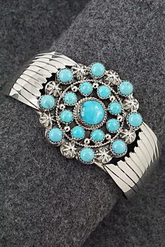 This stunning turquoise and bright-polish sterling silver bracelet was made by Navajo silversmith Jeremy Delgarito. The back is signed J Delgarito and stamped sterling.Size: 5 3/4" (will fit up to a 6 3/4" wrist)Gap: 1"Width: 1 5/8"Free shipping on all orders! We ship with USPS and always include tracking. All orders ship within a day of payment.Returns are accepted up to 30 days after you receive your order. Just send us a message. Our shop offers cash back or store credit. The item must be returned in new condition. Round Turquoise Sterling Silver Cuff Bracelet, Western Style Blue Sterling Silver Bracelet Gift, Western Style Blue Bangle Jewelry, Blue Southwestern Jewelry With Concho, Southwestern Blue Concho Jewelry, Elegant Turquoise Concho Jewelry, Elegant Blue Jewelry With Concho Detail, Southwestern Style Blue Concho Jewelry, Elegant Blue Concho Jewelry