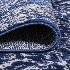 a blue rug with white and black designs on it's edges is laying down